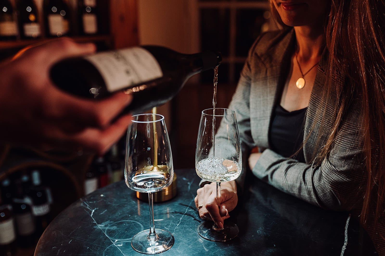 Ein Kellner schenkt einem Gast in der Vinothek Weißwein ein