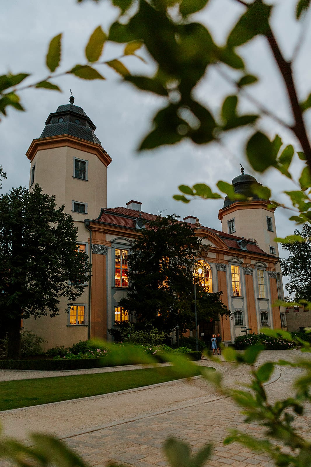 Schloss Książ in der Abenddämmerung im Grünen