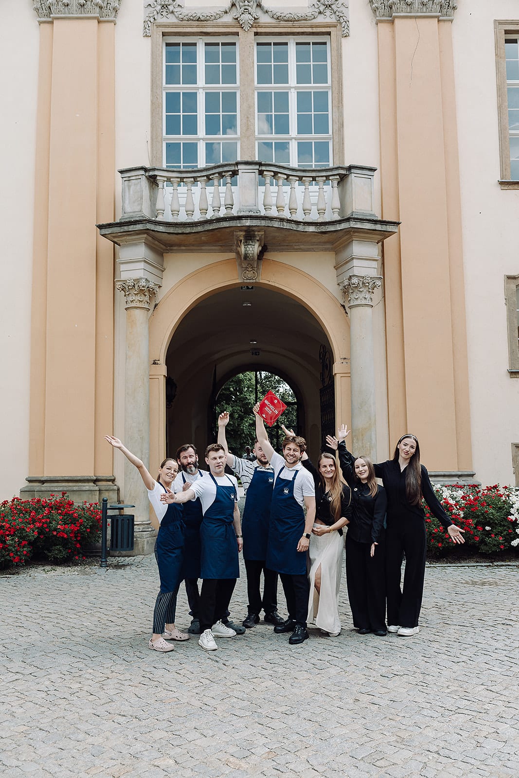Das Restaurantteam mit der MICHELIN-Plakette vor dem Schloss