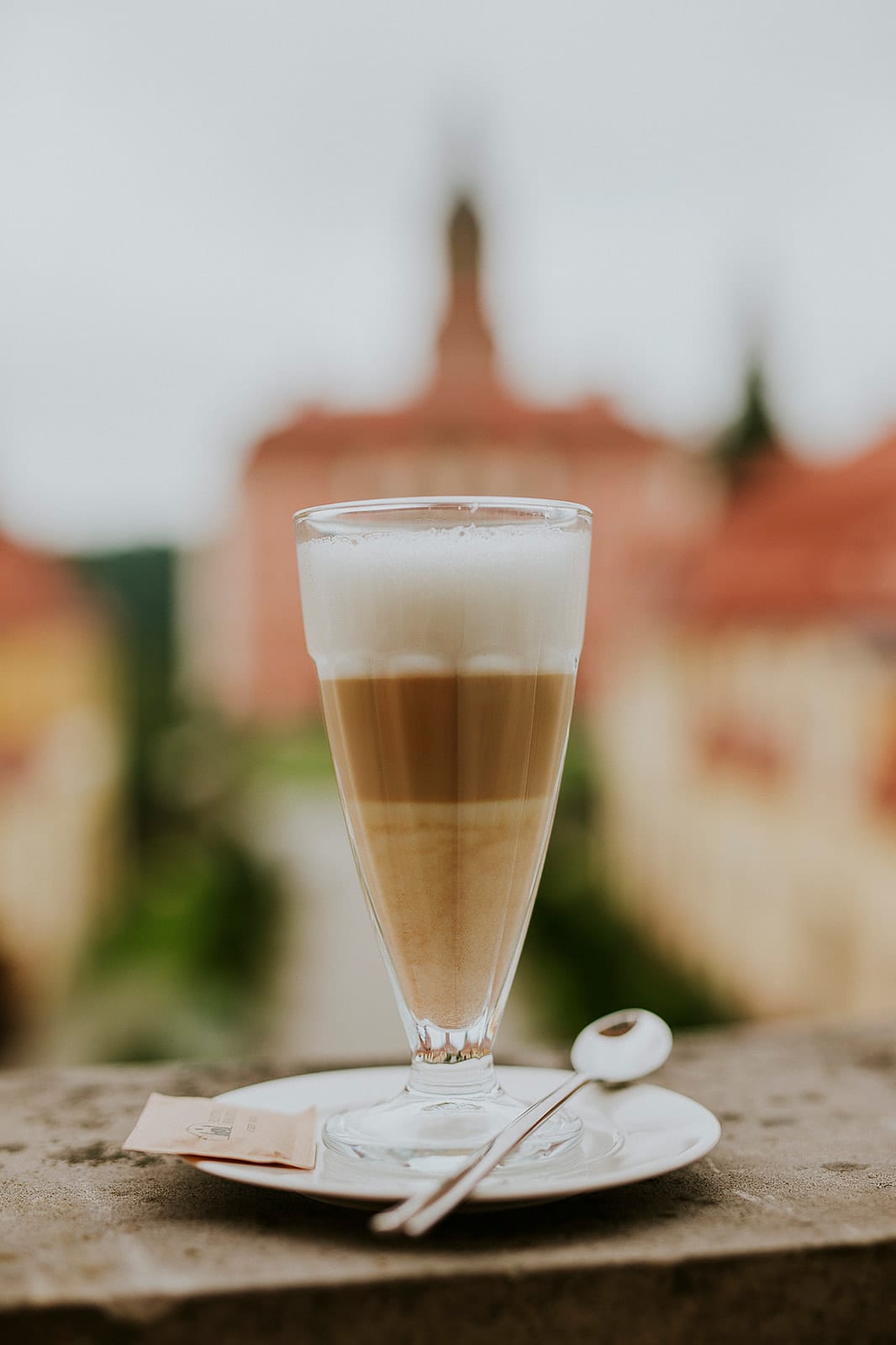 Warstwowe latte macchiato na kamiennym parapecie z widokiem na Zamek Książ